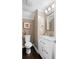 Neutral half bathroom with granite counters, vanity and decorative mirror above the sink at 202 Windcroft Nw Ct, Acworth, GA 30101
