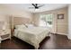 Bedroom with a decorative headboard, ceiling fan, laminate floors, and a sunlit window at 202 Windcroft Nw Ct, Acworth, GA 30101