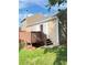 Backyard featuring a wooden deck, complemented by lush greenery and a glimpse of neighboring houses at 2115 Charter Ln, Lithonia, GA 30058