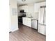 Modern kitchen with stainless steel appliances, white cabinets, and laminate flooring at 2115 Charter Ln, Lithonia, GA 30058