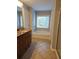 Bright bathroom with a granite vanity, bathtub, and a large window at 6121 Joybrook Rd, Johns Creek, GA 30097