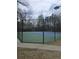Outdoor tennis court with green and blue playing surface and a fence, perfect for recreational activities at 6121 Joybrook Rd, Johns Creek, GA 30097