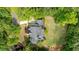 An aerial view shows a well maintained asphalt roof, mature trees, and a verdant lawn at 1575 Spalding Dr, Sandy Springs, GA 30350