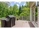 Spacious back deck with wood flooring, an outdoor grill, and stylish railings, perfect for entertaining guests at 1575 Spalding Dr, Sandy Springs, GA 30350