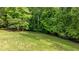 Sloping backyard with lush green grass and mature trees providing privacy and a peaceful outdoor space at 1575 Spalding Dr, Sandy Springs, GA 30350