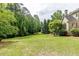 Large backyard with mature trees, a well-manicured lawn, and lush greenery, perfect for outdoor activities and relaxation at 1575 Spalding Dr, Sandy Springs, GA 30350