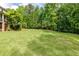 Expansive and well-maintained backyard, featuring lush greenery and mature trees, ideal for outdoor gatherings and activities at 1575 Spalding Dr, Sandy Springs, GA 30350