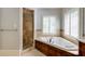 Bathroom featuring a walk-in shower, soaking tub and beautiful white shutters at 1575 Spalding Dr, Sandy Springs, GA 30350
