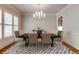 Elegant dining room features a modern chandelier and large window with shutters at 1575 Spalding Dr, Sandy Springs, GA 30350