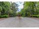 A gated entrance is paved in cobblestones and surrounded by manicured shrubs and mature trees at 1575 Spalding Dr, Sandy Springs, GA 30350