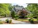 Stunning two-story home with a stone and brick facade, lush landscaping, and a circular driveway at 1575 Spalding Dr, Sandy Springs, GA 30350