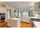 Bright kitchen featuring white cabinets, hardwood floors, a large island, and stainless steel appliances at 1575 Spalding Dr, Sandy Springs, GA 30350