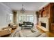 Living room with hardwood floors and a fireplace with wood and stone surround at 1575 Spalding Dr, Sandy Springs, GA 30350
