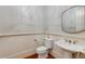 A clean powder room with a pedestal sink and paneled wainscoting at 1575 Spalding Dr, Sandy Springs, GA 30350