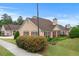 Well-maintained home with tan siding, red shutters, and professionally landscaped yard with mature shrubs at 202 Accord Sw Ln, Grayson, GA 30017