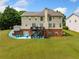 Expansive backyard featuring a deck, patio area with seating, and lush green lawn at 209 Braemar Ct, Mcdonough, GA 30253