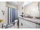 Bright bathroom featuring granite countertops, a white cabinet, and a blue striped shower curtain at 209 Braemar Ct, Mcdonough, GA 30253