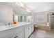Elegant bathroom features double sinks, large mirror, soaking tub, glass shower, and office area at 209 Braemar Ct, Mcdonough, GA 30253