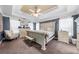 Spacious bedroom features tray ceilings, a ceiling fan and decorative furniture at 209 Braemar Ct, Mcdonough, GA 30253
