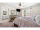 Bedroom with neutral carpet, ceiling fan, television, and doorway to the bathroom at 209 Braemar Ct, Mcdonough, GA 30253