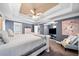 Bedroom with blue walls features a tray ceiling, ceiling fan and seating area at 209 Braemar Ct, Mcdonough, GA 30253