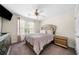 Cozy bedroom featuring a gold headboard, ceiling fan and a window with light pink curtains at 209 Braemar Ct, Mcdonough, GA 30253