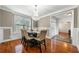 Bright dining room featuring wainscoting, hardwood floors, a modern chandelier, and large windows at 209 Braemar Ct, Mcdonough, GA 30253