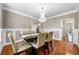 Traditional dining room featuring wainscoting, wood floors, a modern chandelier, and neutral colored walls at 209 Braemar Ct, Mcdonough, GA 30253