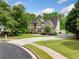 Two-story home with manicured lawn and mature trees, creating a welcoming and picturesque curb appeal at 209 Braemar Ct, Mcdonough, GA 30253