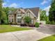 Well-maintained two-story home featuring a large driveway and lush landscaping with mature trees at 209 Braemar Ct, Mcdonough, GA 30253