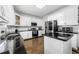 Bright kitchen featuring white cabinets, subway tile backsplash, black countertops and stainless steel appliances at 209 Braemar Ct, Mcdonough, GA 30253