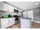 Well-lit kitchen featuring white cabinets, mosaic backsplash, and stainless steel appliances for a modern cooking experience at 209 Braemar Ct, Mcdonough, GA 30253