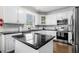 Bright kitchen featuring white cabinets, subway tile backsplash, and black countertops with stainless steel appliances at 209 Braemar Ct, Mcdonough, GA 30253