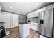Modern kitchen with a central island, stainless steel refrigerator, and white cabinets, offering functionality and style at 209 Braemar Ct, Mcdonough, GA 30253