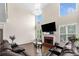 Bright living room with a fireplace, large windows and chandelier, and a comfortable brown leather couch at 209 Braemar Ct, Mcdonough, GA 30253