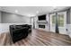 Living room with accent wall and fireplace plus large sectional sofa and hardwood floors at 209 Braemar Ct, Mcdonough, GA 30253