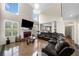 Spacious living room with large windows, marble floors, a leather couch, and a fireplace with a mounted TV at 209 Braemar Ct, Mcdonough, GA 30253