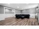 Spacious living room features grey walls, white trim, hardwood floors and black sofa at 209 Braemar Ct, Mcdonough, GA 30253
