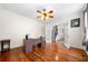 Bright office with hardwood floors, ceiling fan, and open french doors to the entryway with black and white staircase at 209 Braemar Ct, Mcdonough, GA 30253