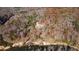An aerial view of a home surrounded by lush trees bordering a river at 3212 Woodhaven Sw Ct, Conyers, GA 30094