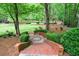 Beautiful backyard featuring brick steps, stone designs, lush shrubs, and tall trees at 4500 Candacraig, Alpharetta, GA 30022