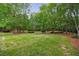 Expansive backyard features lush green lawn and mature trees, offering a private and serene outdoor space at 4500 Candacraig, Alpharetta, GA 30022