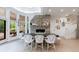 Open dining area with brick fireplace, elegant seating, and access to outdoor patio through bright windows at 4500 Candacraig, Alpharetta, GA 30022