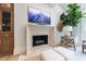 Cozy stone fireplace nook with elegant mantel, wooden cabinet, and leafy potted tree at 4500 Candacraig, Alpharetta, GA 30022