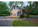 Three-car garage featuring carriage doors, side lights, and a stylish gable window, nestled in a beautifully landscaped yard at 4500 Candacraig, Alpharetta, GA 30022