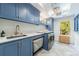 Laundry room with blue cabinetry, modern appliances, and natural light at 4500 Candacraig, Alpharetta, GA 30022