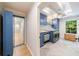 Well-lit laundry room featuring custom blue cabinetry, modern appliances, and herringbone tile flooring at 4500 Candacraig, Alpharetta, GA 30022