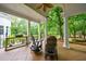 Inviting porch with rocking chairs, a ceiling fan, and a peaceful view of the wooded property at 4500 Candacraig, Alpharetta, GA 30022