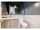 Stylish powder room featuring marble tile, wood vanity with custom hardware, and modern light fixtures at 4500 Candacraig, Alpharetta, GA 30022