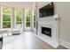 Sitting area with fireplace and large windows looking out to wooded backyard at 4500 Candacraig, Alpharetta, GA 30022